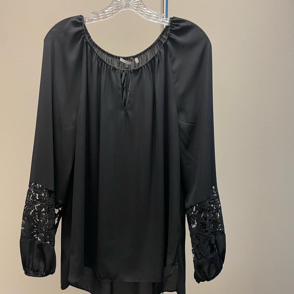 Black shirt with bell sleeve and lace trim.